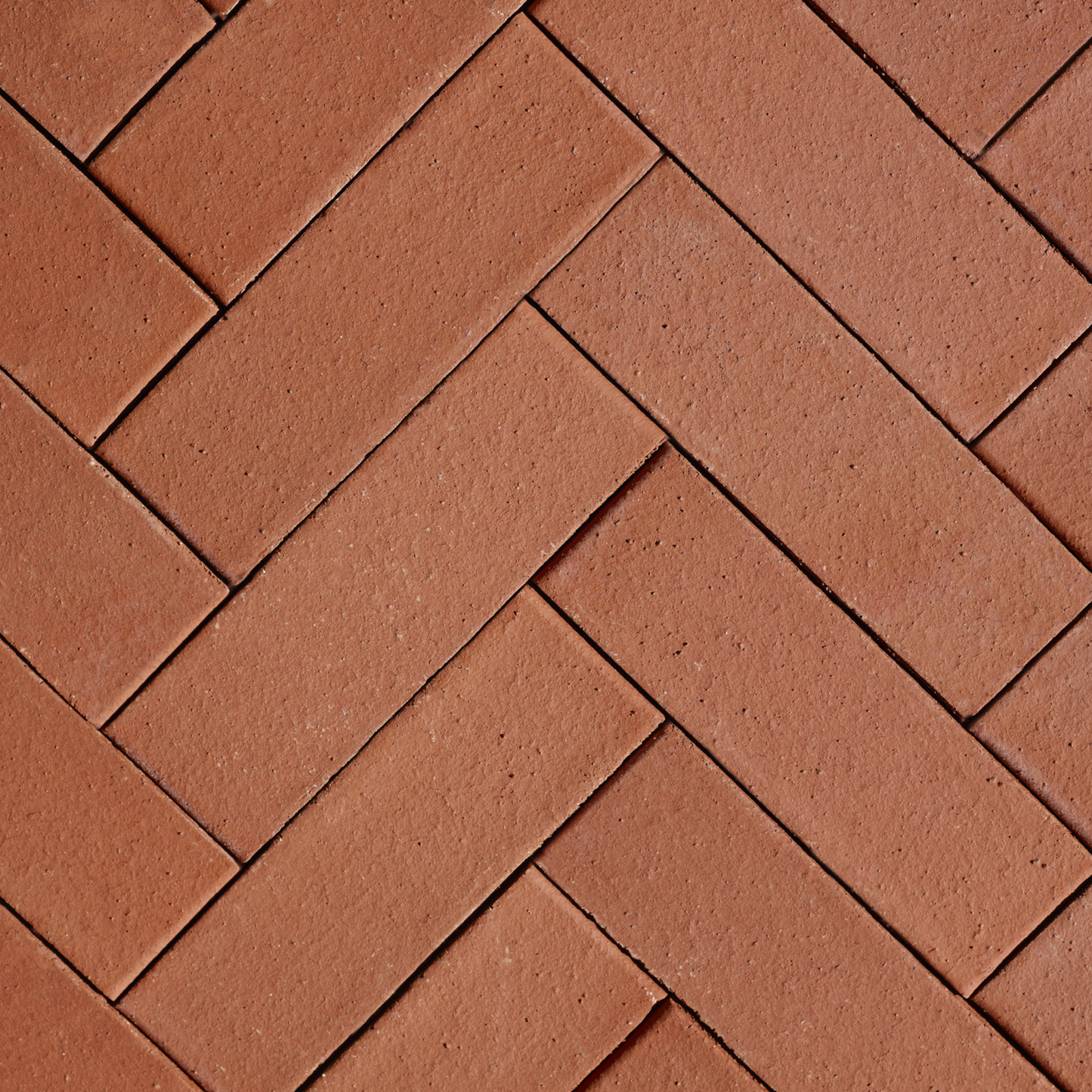 Pattern of brown bricks arranged in a herringbone design