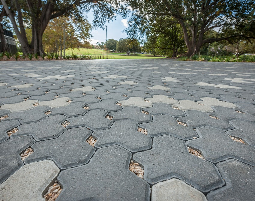 ecotrihex stone pavement in a park setting with trees and grass.