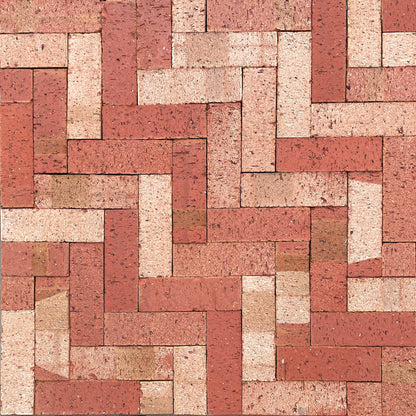 Pattern of red and beige bricks arranged in a herringbone pattern.
