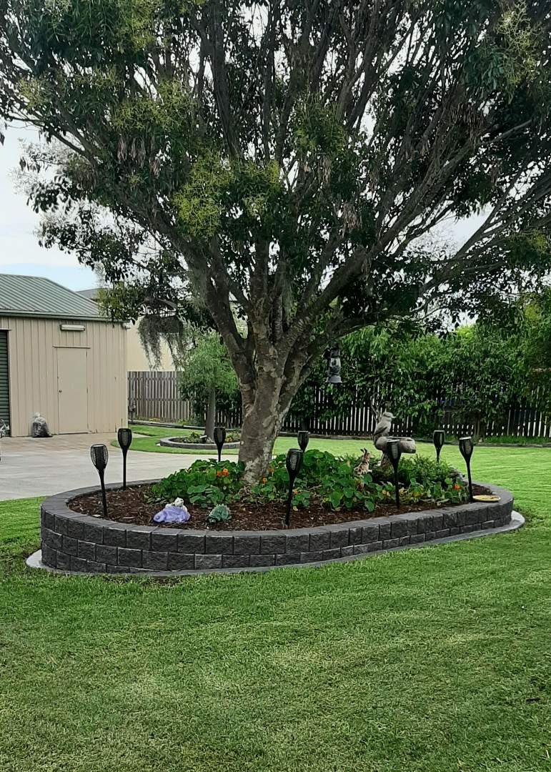 Garden bed with a tree and decorative elements in a residential setting
